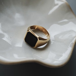Makroaufnahme des Rings, die die goldene Struktur und glatte Textur zeigt. Das Handwerk offenbart Liebe zum Detail und Qualität.