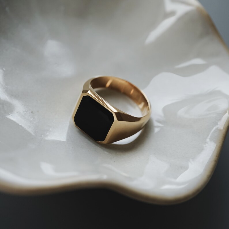 Makroaufnahme des Rings, die die goldene Struktur und glatte Textur zeigt. Das Handwerk offenbart Liebe zum Detail und Qualität.