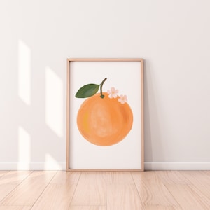 May include: A framed illustration of an orange with a green leaf and pink flowers on top. The orange is painted in a watercolor style with a light orange color.