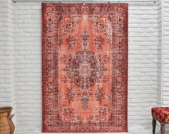 May include: A vintage-style rug with a red and black floral pattern. The rug is hanging on a white brick wall.