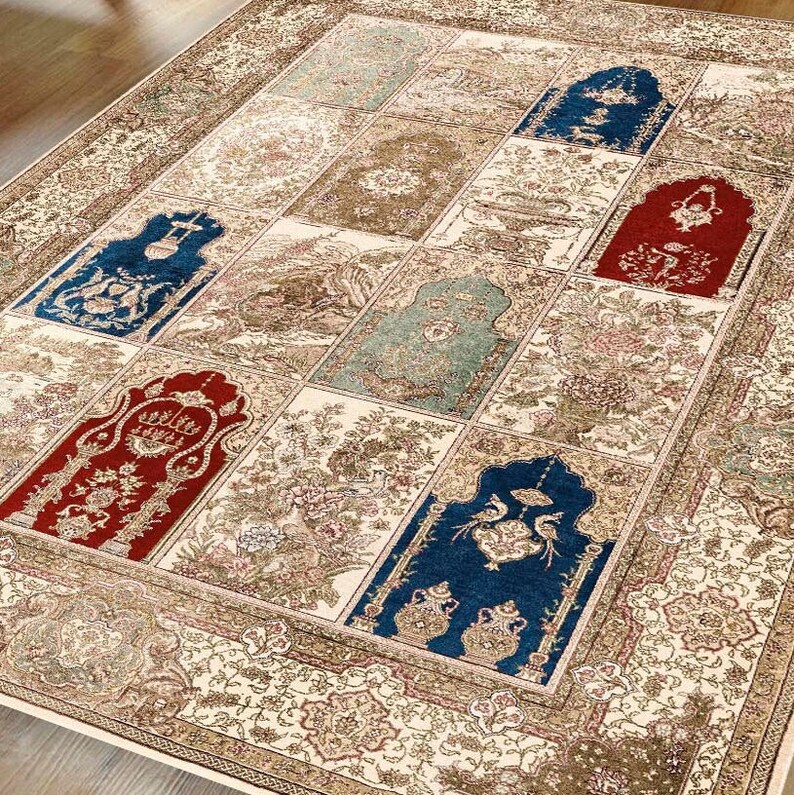 May include: A cream-colored rug with a patchwork design featuring blue, red, and green accents. The rug has a detailed floral pattern and a border with intricate designs.