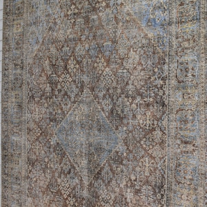 May include: A brown and blue patterned rug with a diamond-shaped design in the center. The rug has a distressed look and a vintage feel.