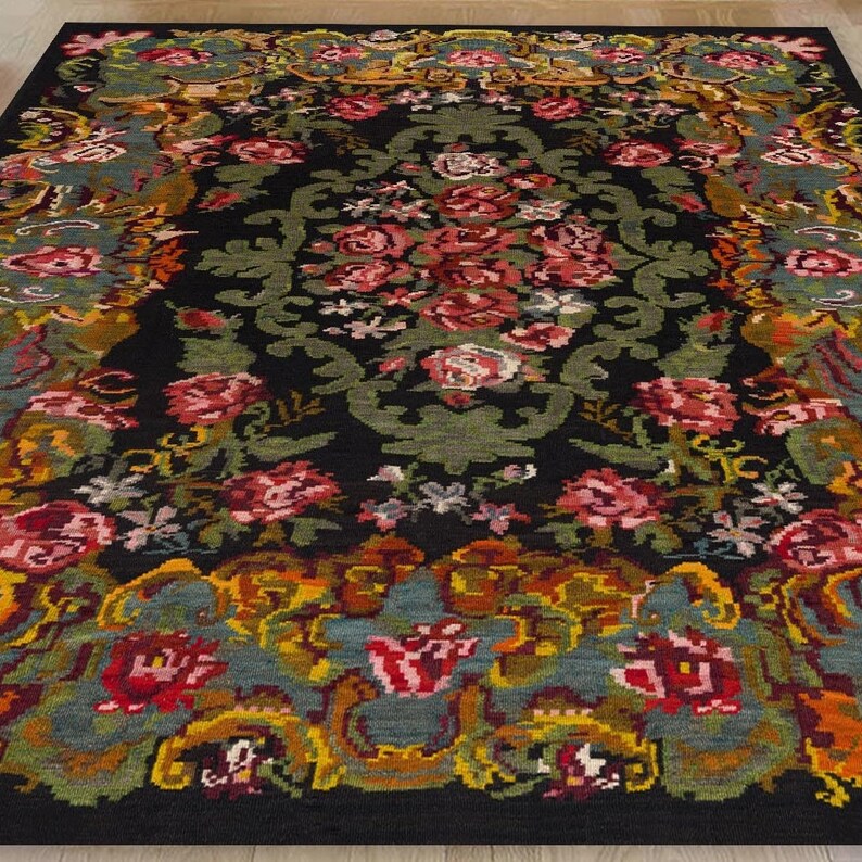 May include: A black rug with a floral pattern in shades of red, pink, yellow, green, and blue. The rug has a detailed design with intricate details.