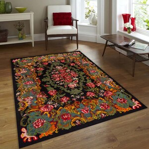 May include: A black area rug with a floral pattern in shades of red, orange, yellow, green, and blue. The rug has a detailed design with intricate floral motifs and a central medallion.