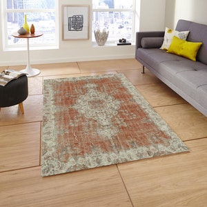 Puede incluir: Una alfombra de estilo vintage desgastada con un fondo rojo descolorido y un patr&oacute;n floral blanco. La alfombra tiene un aspecto desgastado y envejecido, lo que le da un atractivo r&uacute;stico y encantador.