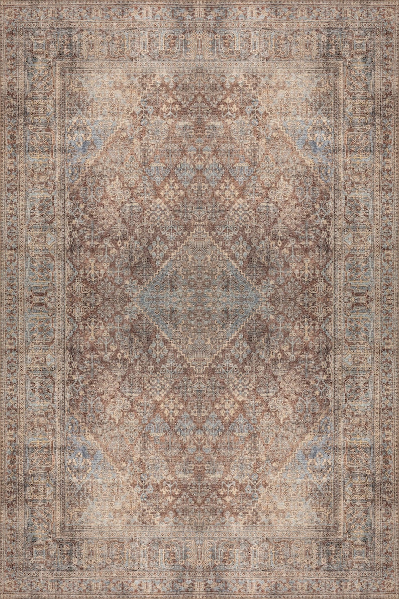 May include: A vintage-style rug with a brown, beige, and blue color scheme. The rug features a central diamond pattern surrounded by intricate floral and geometric designs.