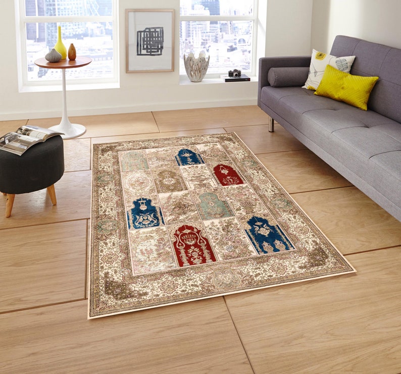 May include: A beige area rug with a patterned design featuring multiple arches in shades of blue, red, and green. The rug has a cream-colored background with a floral border.