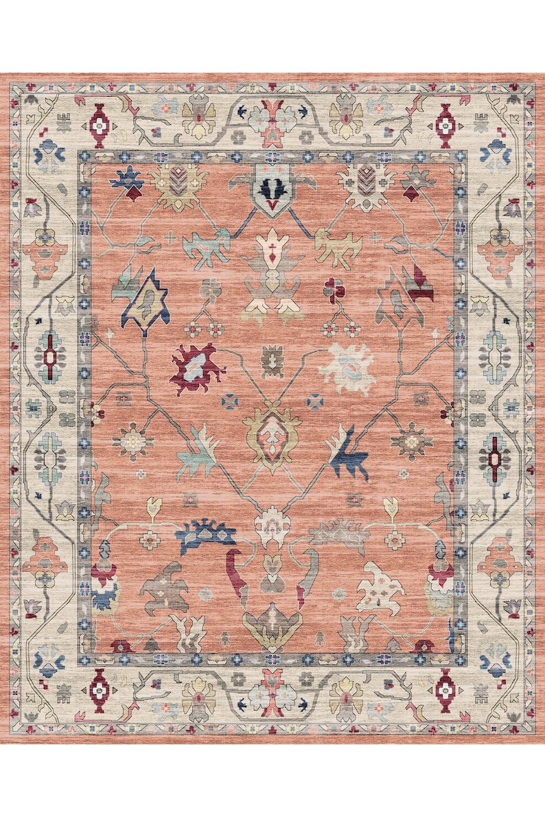 May include: A peach-colored rug with a traditional Persian design. The rug has a cream-colored border with intricate floral patterns. The center of the rug features a repeating pattern of stylized flowers and leaves.