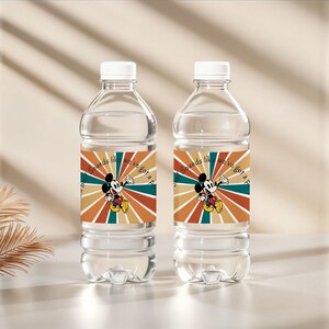 May include: Two clear plastic water bottles with white caps. Each bottle has a label featuring Mickey Mouse and the text "Sounds like we've got a party". The label has a retro color scheme of orange, teal, and brown.