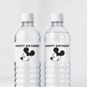 May include: Two clear plastic water bottles with white caps. Each bottle has a label with the text "HAPPY BIRTHDAY" above a black and white cartoon mouse face. The bottles are filled with clear liquid.