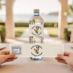 May include: A clear plastic water bottle with a beige label featuring a cartoon dog and the text "Matthew's 5th Birthday." The label also includes a nutrition facts table. The bottle is held by hands.