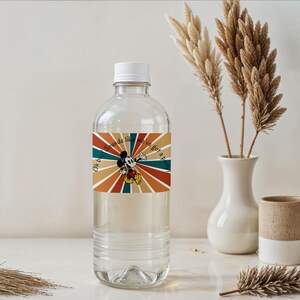 May include: A clear plastic water bottle with a white cap and a colorful label featuring Mickey Mouse and the text "Oh boy, Sounds like we've got a party". The label has a retro design with orange, brown, and teal stripes.