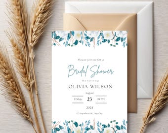 May include: A white invitation card for a bridal shower with floral and leaf accents in white and teal. The text reads "Bridal Shower" and includes the honoree's name, date, time, and address. A beige envelope and wheat stalks are in the background.