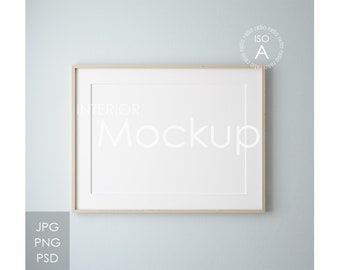 May include: A light wood framed picture mockup with a white background. The frame is on a light blue wall. The text "INTERIOR MOCKUP" is visible in the image.
