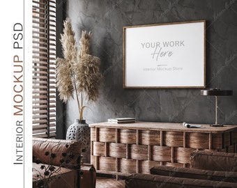 May include: A framed poster with the text "Your Work Here" and "Interior Mockup Store" hanging on a textured gray wall. The poster is above a wooden cabinet with a woven design. There are dried pampas grasses in a vase to the left of the cabinet.