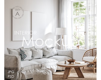 May include: A white living room with a white couch, two white framed pictures, a wooden coffee table, a wicker chair, and a white lamp. The text "INTERIOR MOCKUP" is written in black on the wall.