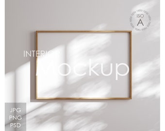 May include: A wooden frame mockup with a white background. The frame is hanging on a white wall with light shining through a window, casting shadows on the wall.