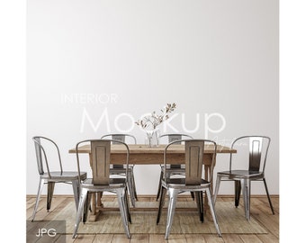 May include: A rustic wooden dining table with six silver metal chairs. The table is set with a vase of dried flowers in the center. The chairs have a simple design with a curved back and a metal frame.