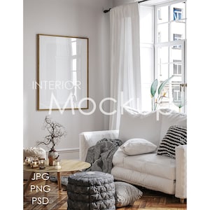Puede incluir: Maqueta de interior con un sofá blanco, una mesa de centro redonda de madera y una obra de arte enmarcada. La habitación tiene una ventana grande con cortinas blancas y un otomán estampado. El texto "INTERIOR MOCKUP" es visible en la pared.