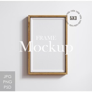 以下が含まれることがあります： 白い内装の長方形の木製フレームモックアップ。「FRAME Mockup」の文字が白いスペースの中央に配置されています。フレームには「5X3」のラベルが付いており、JPG、PNG、PSDのラベルが付いています。