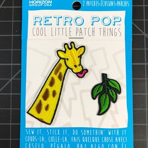 以下が含まれることがあります： アイロン接着できるパッチが2枚、1枚は黄色のキリン、もう1枚は緑の葉っぱ。パッケージには「レトロポップ クールリトルパッチシングス」と「縫い付けたり、貼り付けたり、何かしてね！」と書かれている