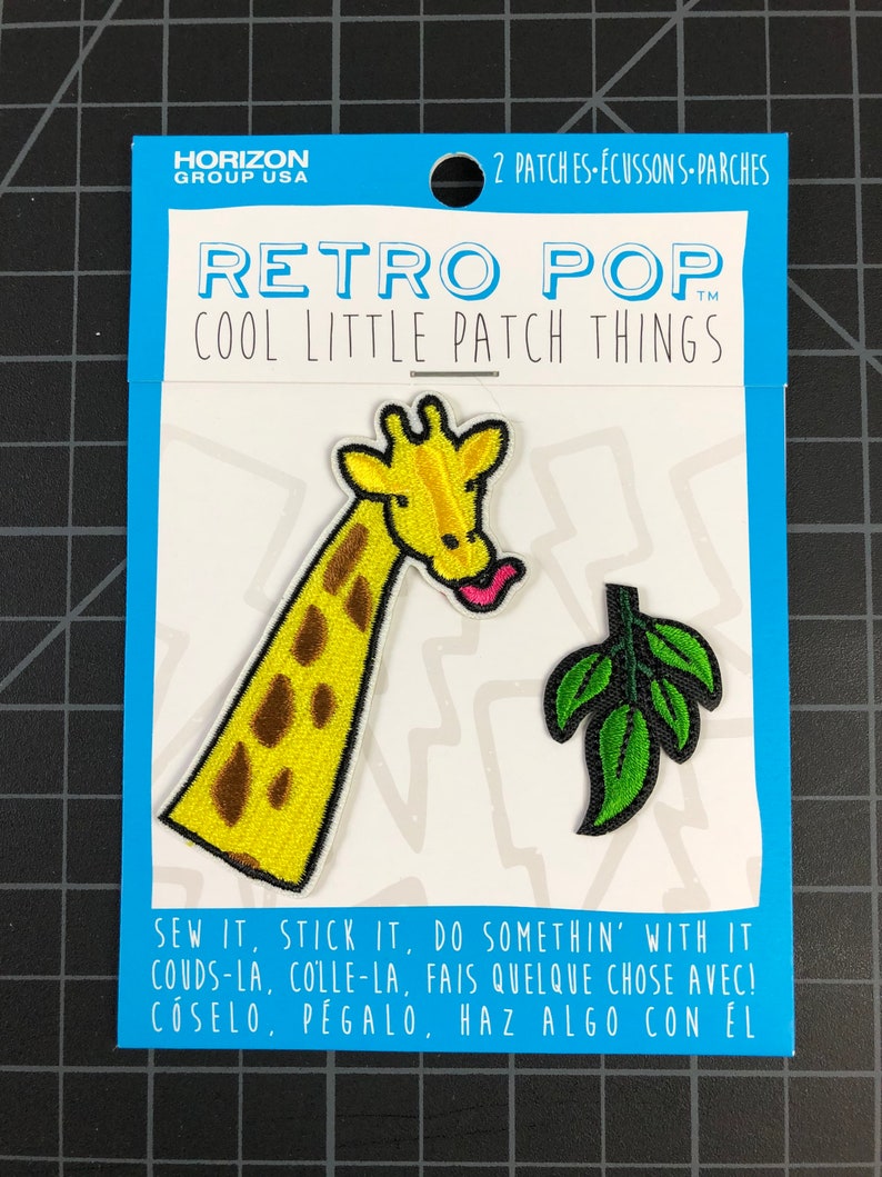 以下が含まれることがあります： アイロン接着できるパッチが2枚、1枚は黄色のキリン、もう1枚は緑の葉っぱ。パッケージには「レトロポップ クールリトルパッチシングス」と「縫い付けたり、貼り付けたり、何かしてね！」と書かれている
