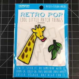 以下が含まれることがあります： アイロン接着できるパッチが2枚。1枚は茶色の斑点のある黄色いキリンで、ピンクの舌が出ています。もう1枚は緑の葉っぱです。パッケージには「レトロポップ クールリトルパッチシングス」と「縫い付けたり、貼り付けたり、何かしてね！」と書かれています。
