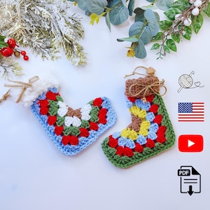 May include: Two handmade crochet Christmas stockings. The stockings feature a colourful granny square design in red, green, blue, white, and yellow. Each stocking has a white fluffy cuff and a brown twine loop for hanging.