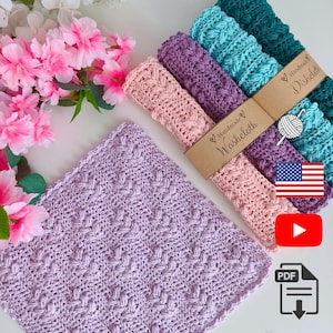 May include: A collection of handmade crochet washcloths and dishcloths in various colors, including pink, purple, teal, and green. Each cloth features a textured pattern and is labeled with a brown tag that says "Handmade Washcloth" or "Handmade Dishcloth".