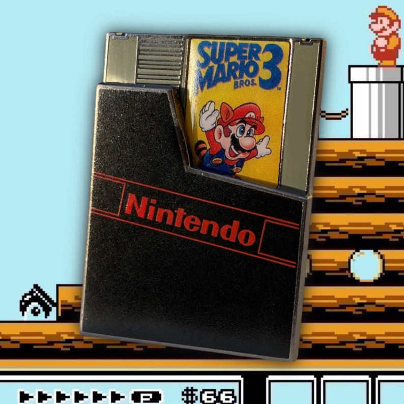 May include: A black and red Nintendo game cartridge with a silver trim. The cartridge is labelled "Super Mario Bros. 3". The cartridge is partially inserted into a black Nintendo Entertainment System game case.