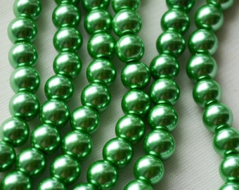 May include: A strand of green pearl beads. The beads are round and have a smooth, shiny finish.