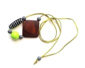 Pendant necklace of upcycled treasures on olive green faux suede thong- glass and square wood beads.
