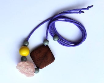 Pendant necklace of upcycled treasures on lilac cord raw crystal and chunky wood beads.