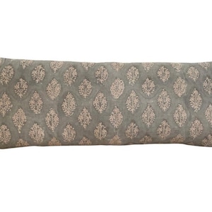 May include: A long, rectangular pillow with a light green background and a white floral pattern.