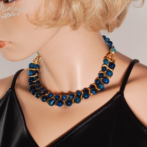 May include: A double-strand necklace with blue agate beads and gold accents. The necklace is on a mannequin wearing a black top.