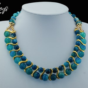 May include: A double-strand necklace with blue agate beads and gold accents. The beads are graduated in size and have a swirling pattern.