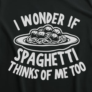May include: A black t-shirt with white text that reads "I wonder if spaghetti thinks of me too". The text is accompanied by a graphic of a plate of spaghetti with meatballs.
