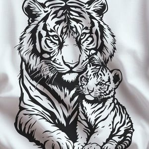 May include: White t-shirt featuring a black and white illustration of a tiger and cub. The tiger is depicted with detailed stripes and a focused gaze, with the cub nestled close. The shirt also includes the text "This Feels So Good" and "SVG and PNG File Format".