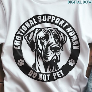 以下が含まれることがあります： 犬の頭部の白黒のグラフィックデザインが施された白いTシャツ。グラフィックには、犬の頭部の周りに「Emotional Support Human」と「Do Not Pet」と書かれています。