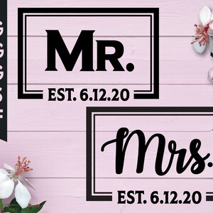 May include: Two black framed signs with white text. The top sign says "MR. EST. 6.12.20" and the bottom sign says "Mrs. EST. 6.12.20".