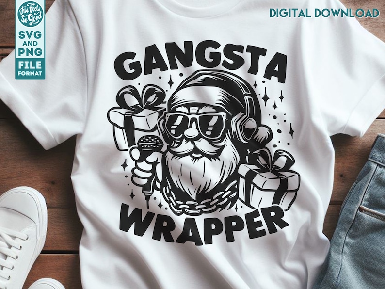 May include: A white t-shirt with a black graphic of Santa Claus wearing sunglasses and headphones, holding a microphone and a gift box. The text "Gangsta Wrapper" is printed below the image.