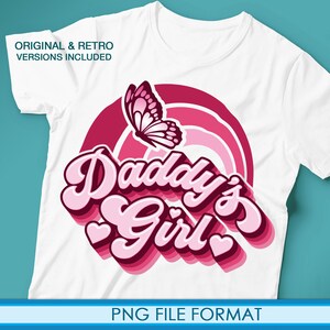 Op de afbeelding: Wit T-shirt met een roze en rood grafisch ontwerp met een vlinder en de tekst "Daddy's Girl" in een retro-lettertype.
