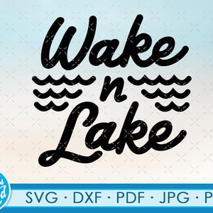 Pu&ograve; includere: Grafica in bianco e nero con il testo "Wake n Lake" in un font stilizzato. Il testo &egrave; circondato da tre linee ondulate, che rappresentano l'acqua.