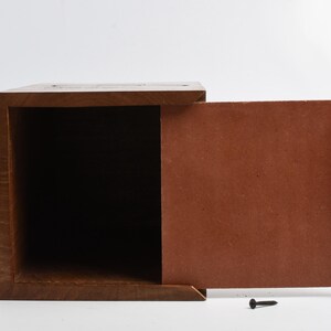 May include: A wooden box with a hinged lid. The box is open and the inside is empty. The box is made of dark wood and has a natural finish.