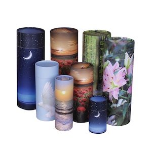 May include: A selection of cylindrical urns, each decorated with a different nature scene. Designs include a sunset over poppies, a forest, a dove, a sunrise over the sea, and a night sky with a crescent moon. The colour palette includes blue, pink, and brown.