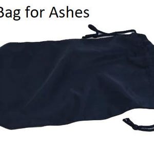 May include: A navy blue drawstring bag for ashes. The bag is made of a soft, opaque material and has a drawstring closure at the top. The text "Bag for Ashes" is printed in black at the top of the image.