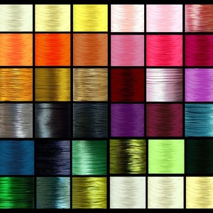 May include: A collection of 48 spools of thread in various colours, including white, yellow, orange, red, brown, grey, blue, green, and black. The spools are arranged in a grid pattern.