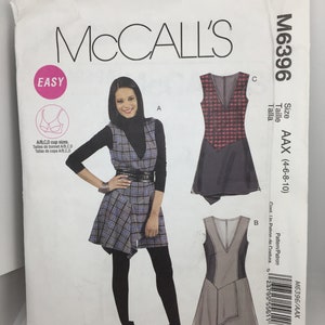 Könnte beinhalten: Ein Schnittmuster für ein Kleid mit V-Ausschnitt und asymmetrischem Saum. Das Schnittmuster ist für die Größen 4-6-8-10. Das Schnittmuster heißt McCall's M6396.