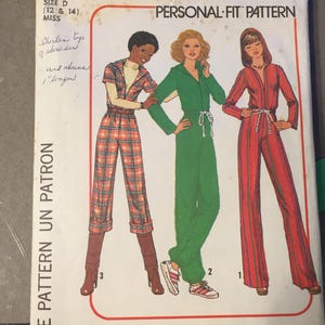 May include: Vintage Simplicity sewing pattern 7916 for a jumpsuit. The pattern features three jumpsuit designs in various colours and patterns, including a plaid, green, and striped option. The pattern is size D (12 & 14) and includes the text "PERSONAL-FIT PATTERN".
