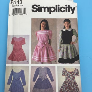 May include: Simplicity sewing pattern with dress designs for sizes 7-14. The packet shows dresses in pink, blue, and floral prints. The pattern number is 8143. The word "Simplicity" is printed in black.